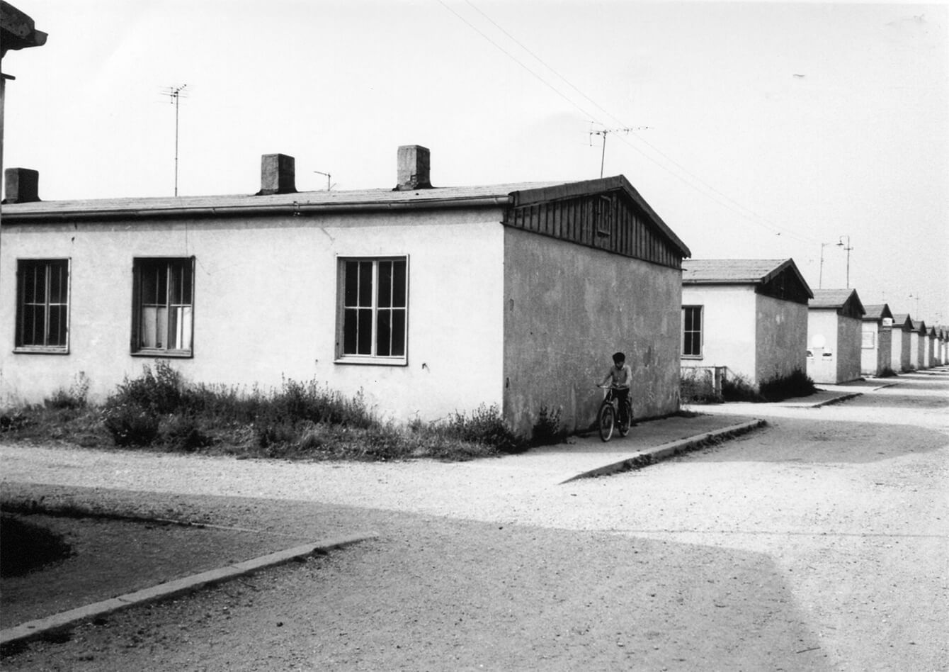 Ehemalige Häftlingsbaracken, umgebaut zu Wohnungen (ca. 1960). In den Baracken waren jeweils 16 Zweizimmer- und acht Einzimmerwohnungen entstanden.